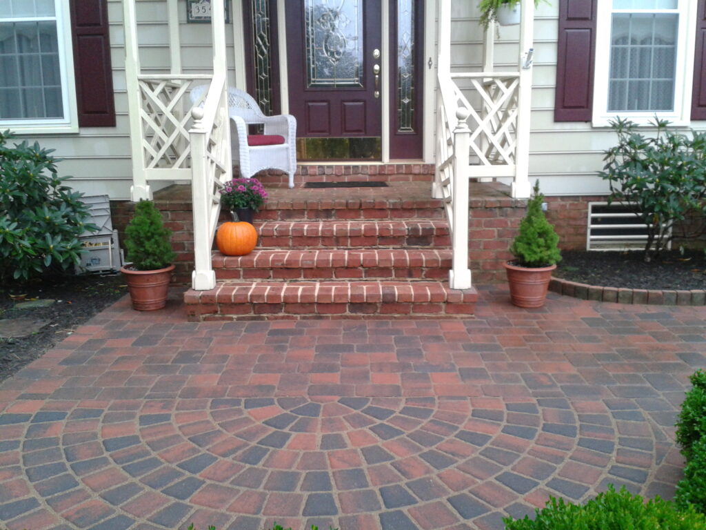 FRONT ENTRANCE - Mortared brick steps and inlay, Cobblestone walkway with half-circle pad. Curbstone bed border.